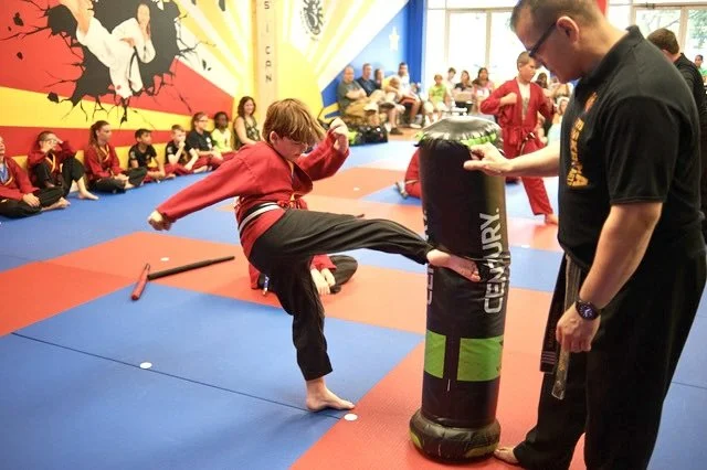 Boy kicking a kicking bag during martial arts summer camp at Rising Sun Jupiter in Abacoa, Fl.