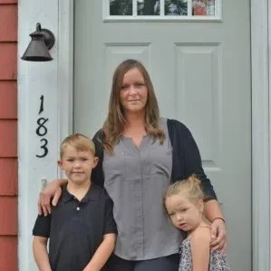 Homeowner Jess with her kids, Drew and Jillian, in front of their new home.