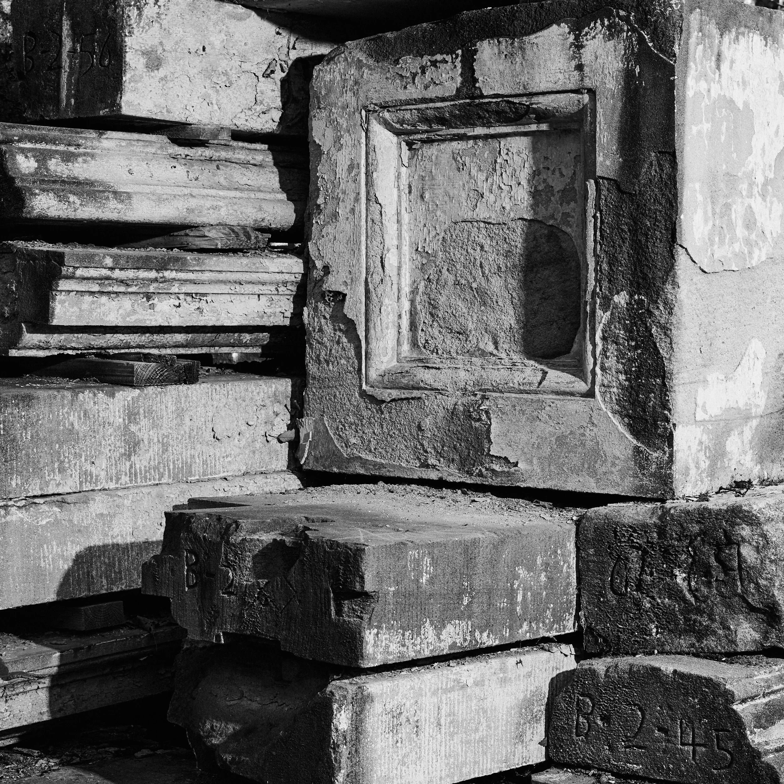 Close-up view of a weathered and cracked stone or concrete structure with various textures and irregular surfaces.
