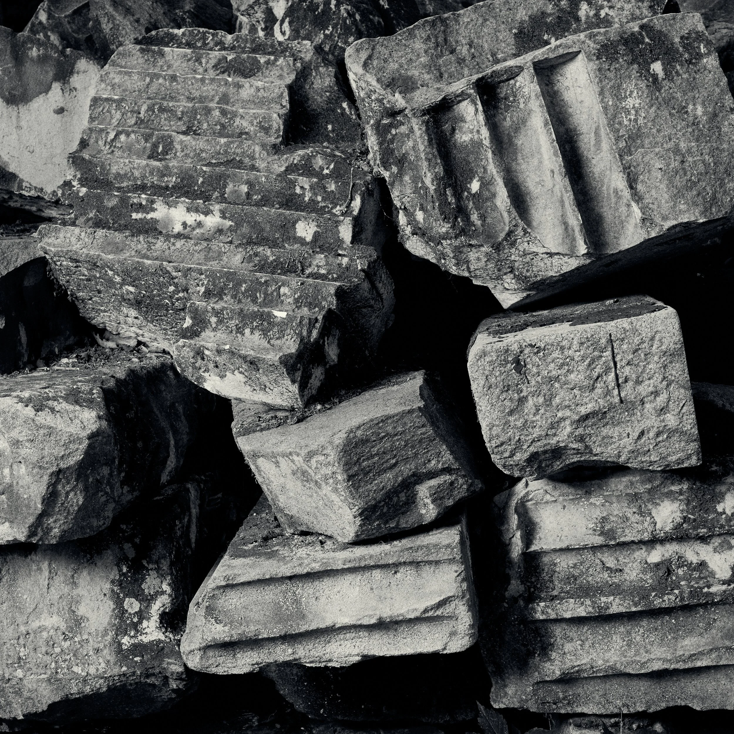 Close-up of gray, rough-textured rocks with visible layers and cracks.