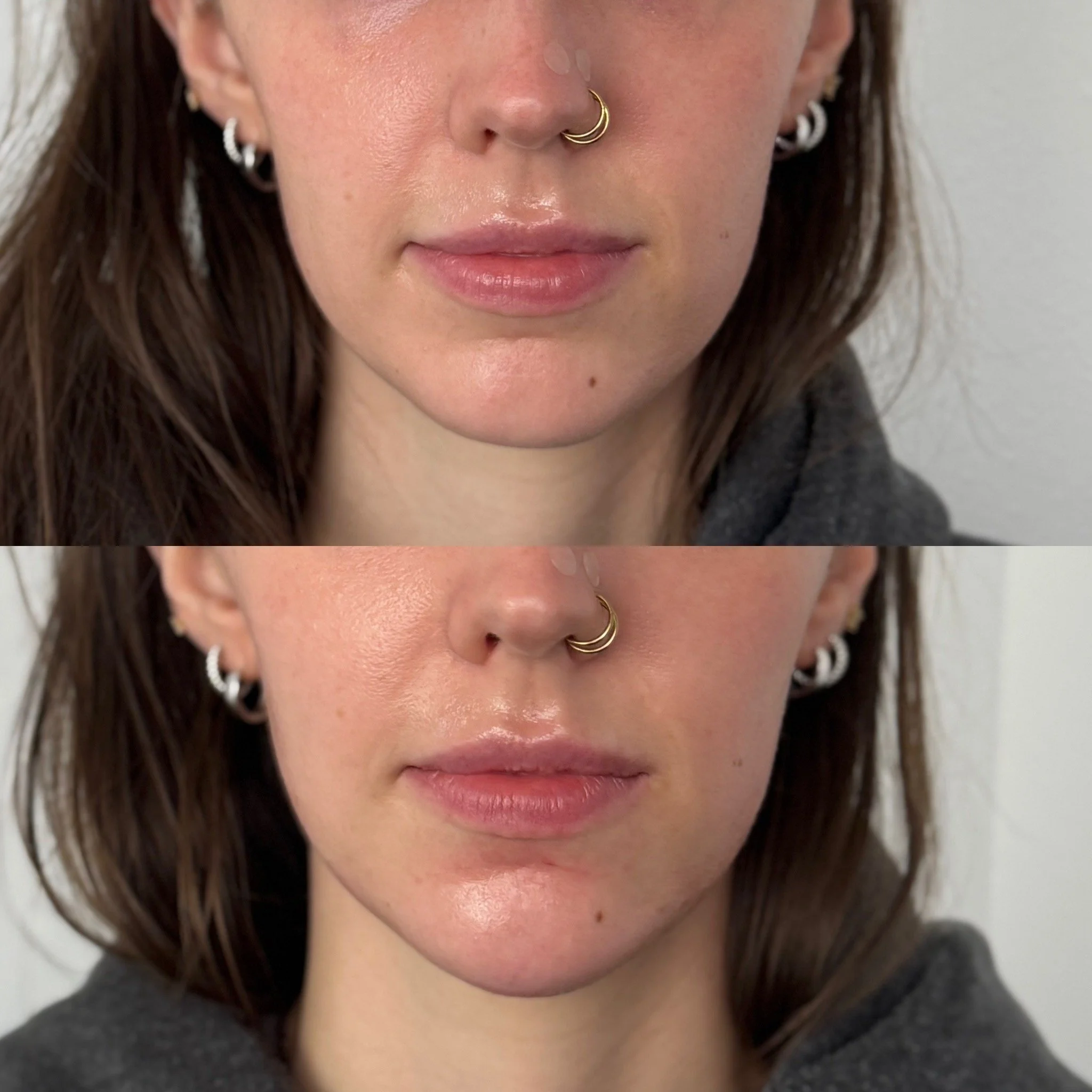 Close-up of a woman's lower face, showing lips, nose, earrings, and septum piercing, with the top half of the image slightly darker and more shadowed than the bottom half.