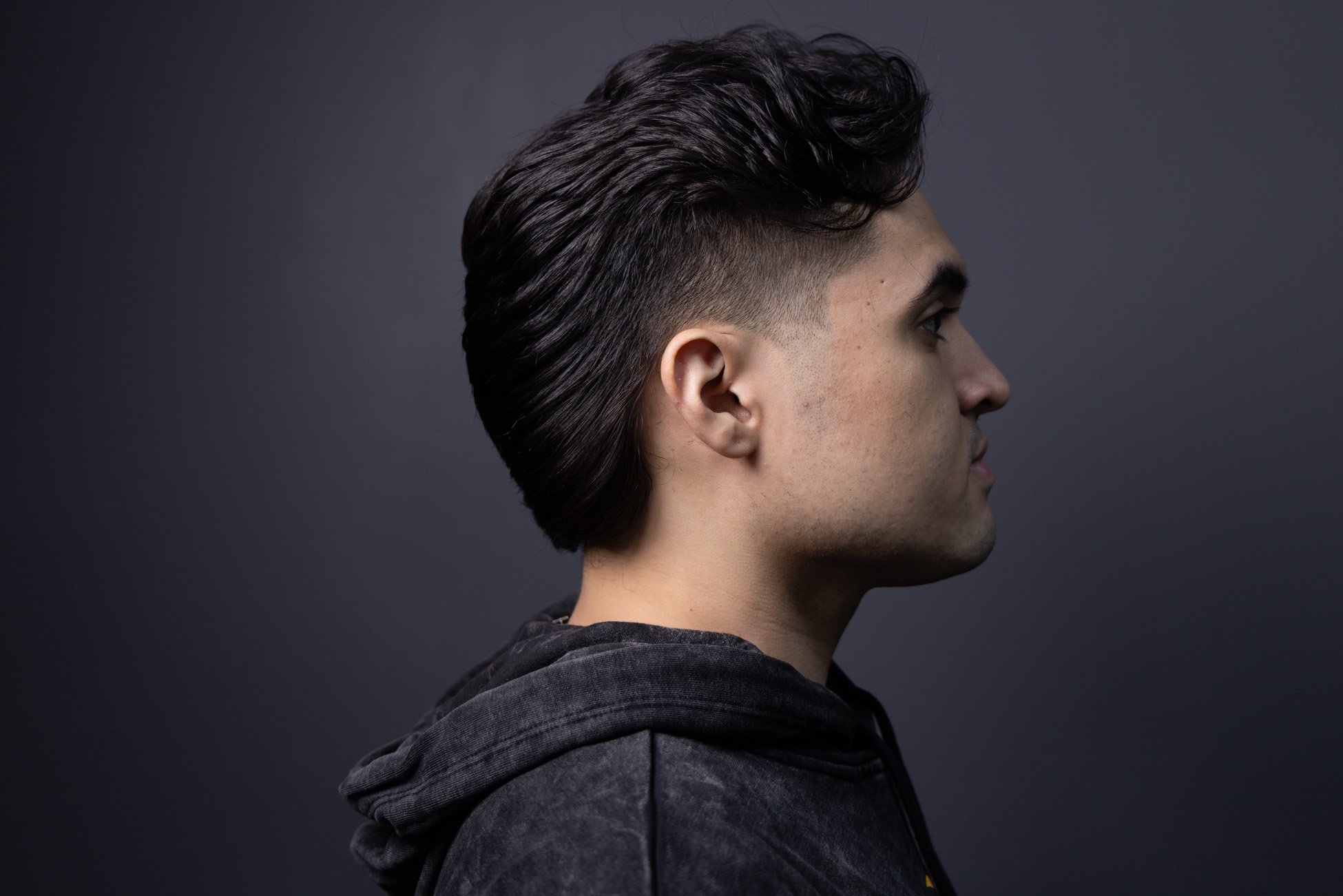 Modern men's mullet haircut on black hair with front taper