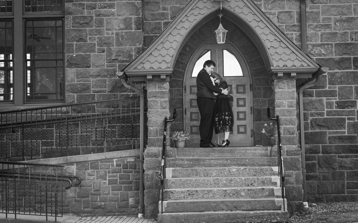 Black and white engagement photo of a soon to be married couple outside milford CT based church.
