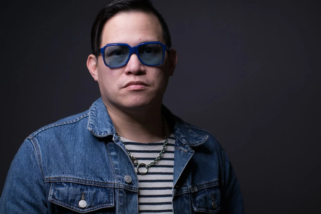 Headshot photo sitting for asian man wearing designer clothes and designer eyeglasses