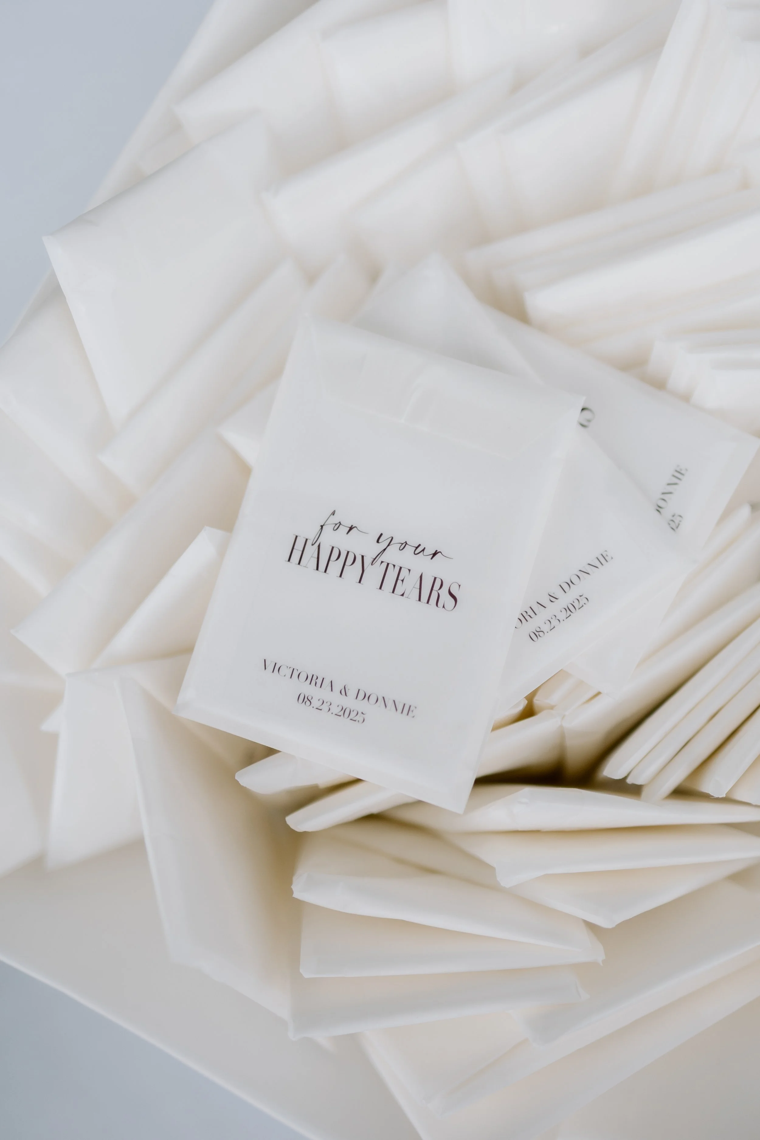 Close-up of white paper packets with printed text, scattered on a white surface.