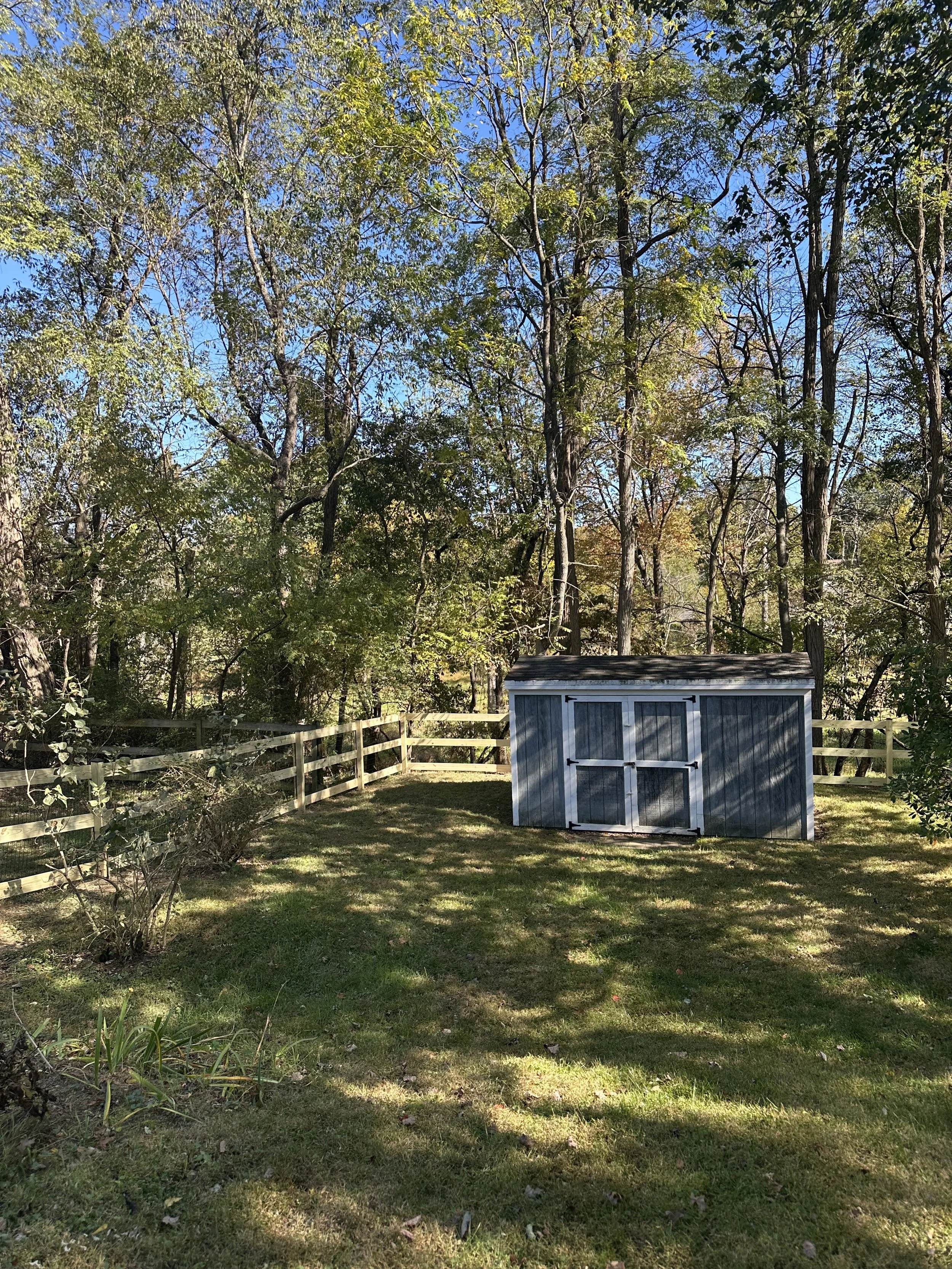 3-board paddock fence with wire mesh in woods in Ellicott City
