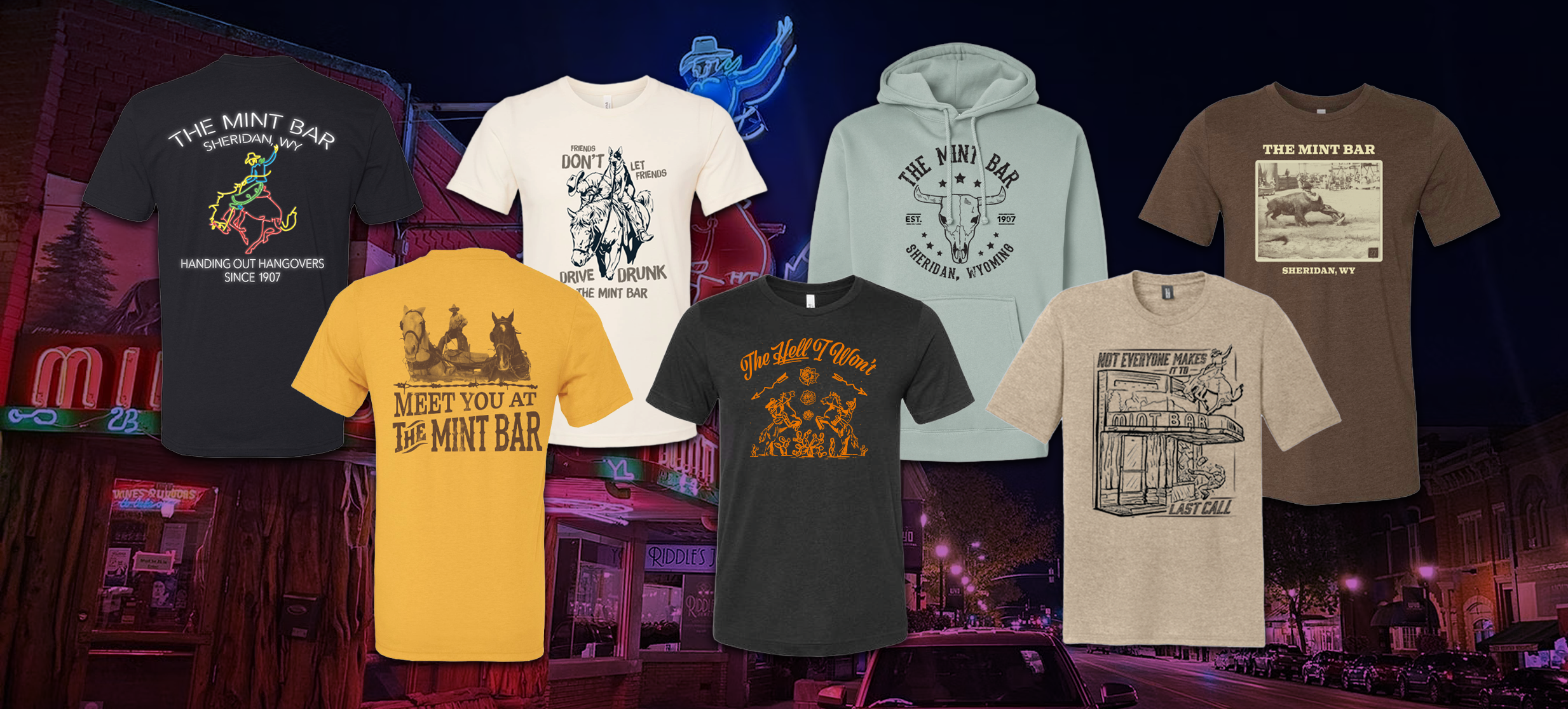 A collection of various T-shirts and a hoodie with western-themed and bar-related graphics and text, displayed against a nighttime street scene with neon signs.