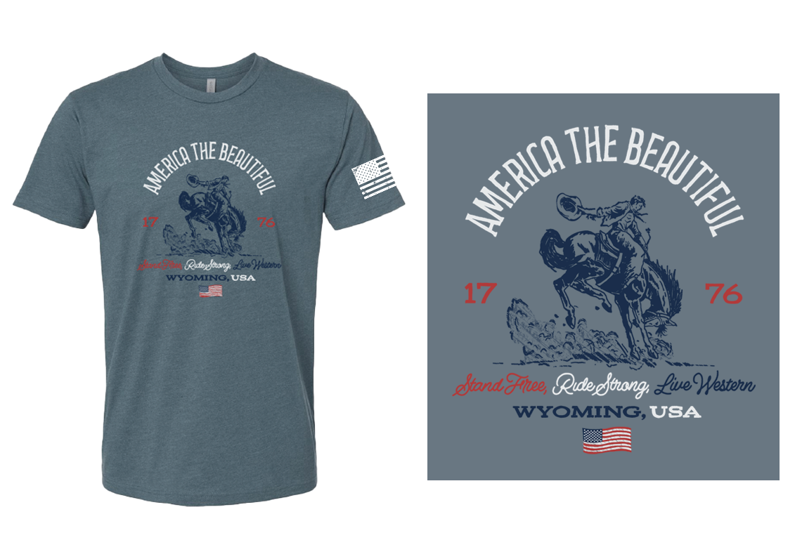T-shirt with graphic design featuring a cowboy riding a bucking horse, the phrase 'America the Beautiful,' and the year '1776'. It also includes American flags and the words 'Stand Free, Ride Strong, Live Western,' with 'Wyoming, USA' printed below.