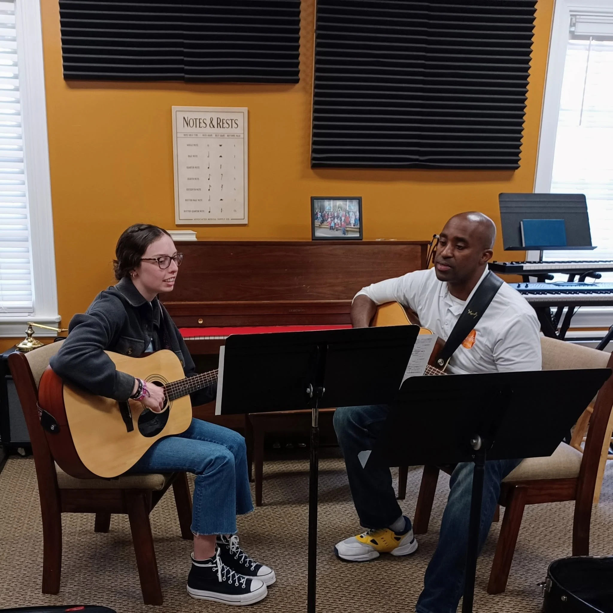 instructor and student playing guitars