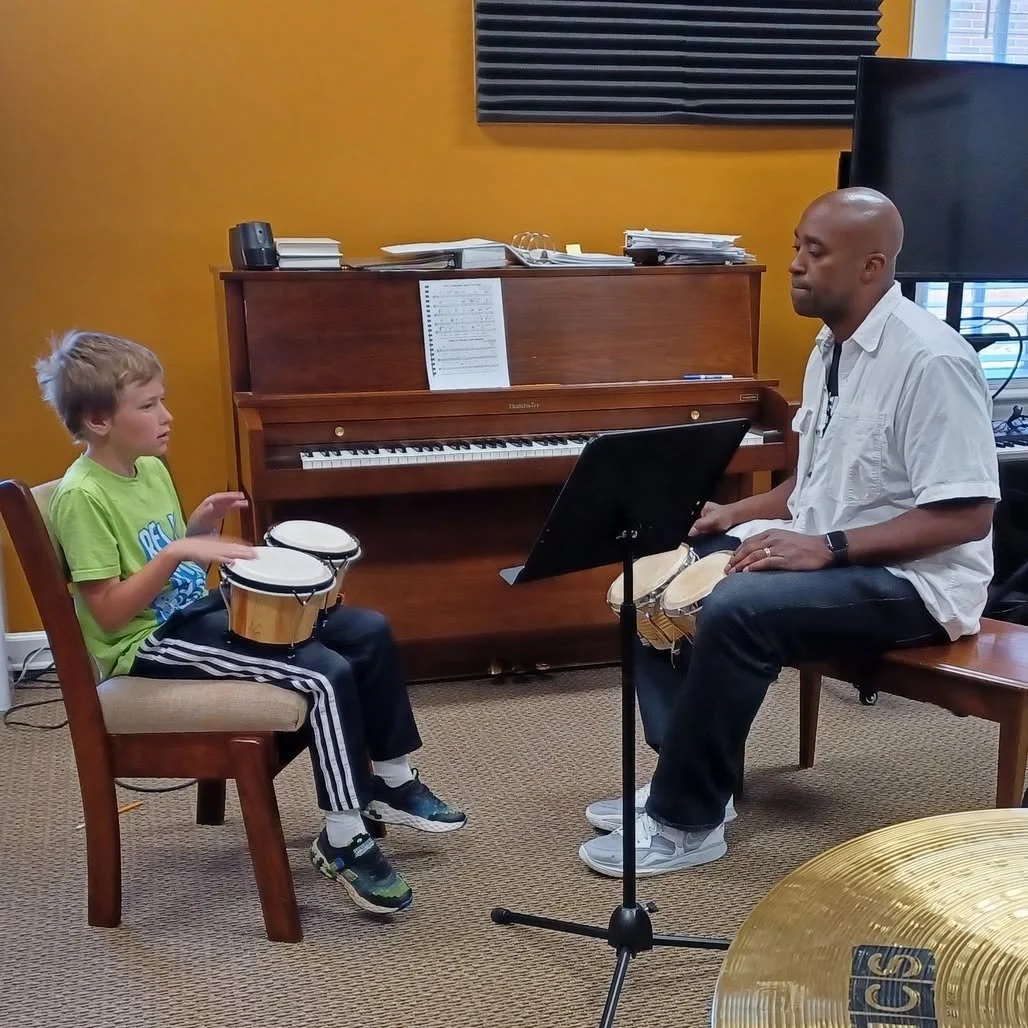 Music instructor and student playing bongo drums