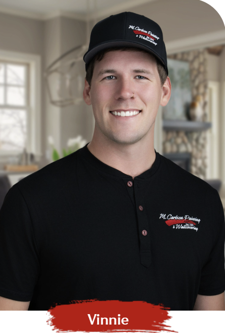 Man in black cap and shirt smiling in a home interior.