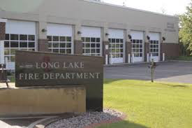 Exterior of Long Lake Fire Department building with garage bays and a sign in front.