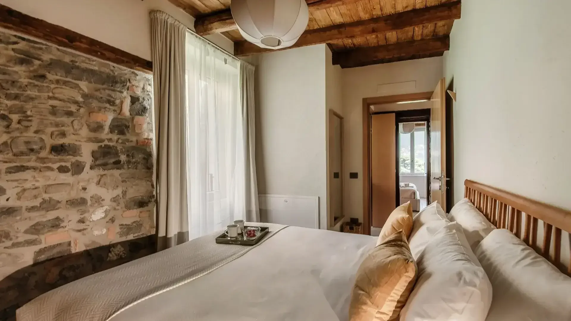 Cozy bedroom with stone walls and wooden beams