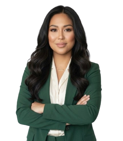 A confident woman with long, dark hair, wearing a green blazer over a white shirt, standing with arms crossed against a plain background.