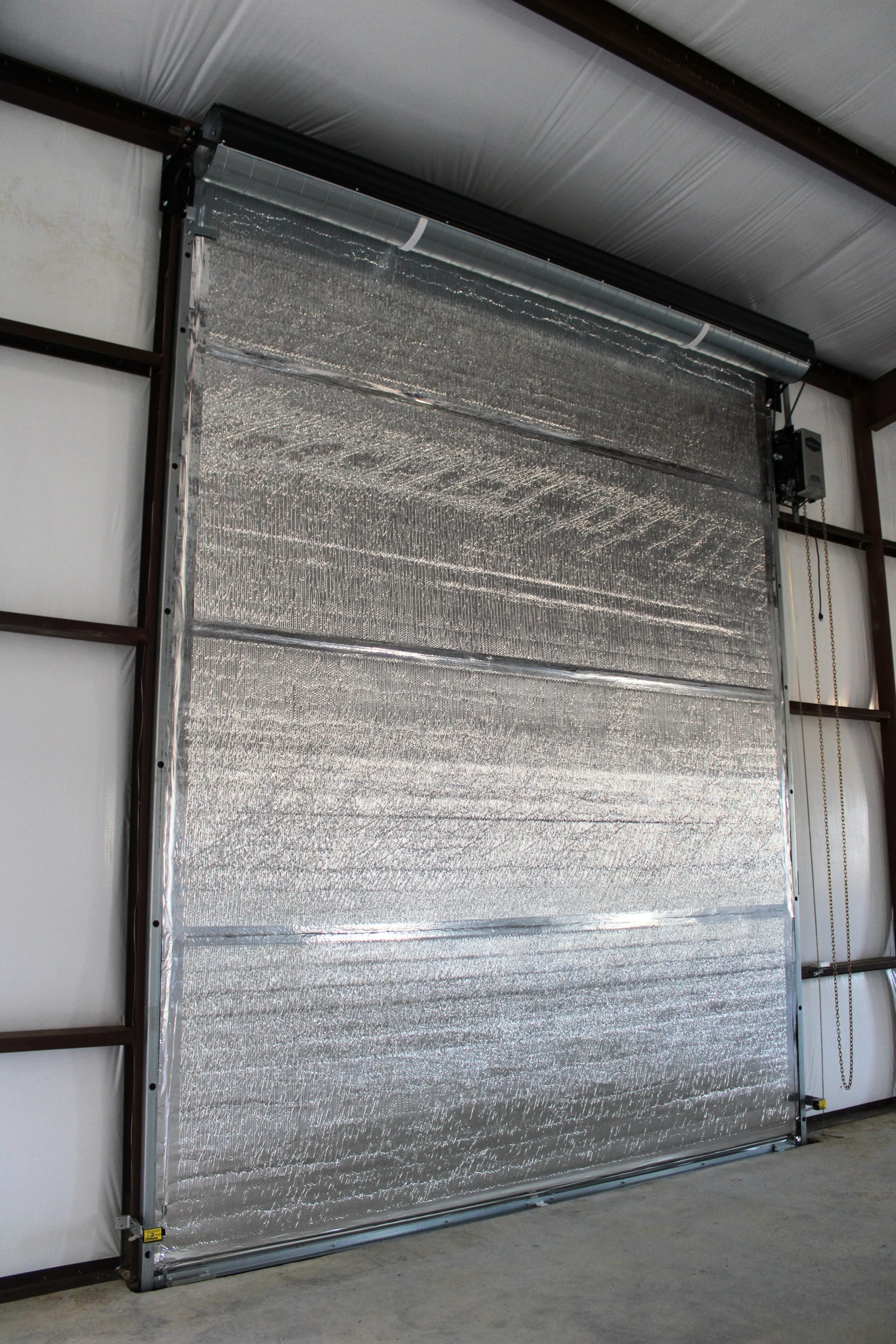 Interior view of insulated roll-up doors inside a custom metal shop in Wallis, TX providing smooth access and efficient traffic flow.