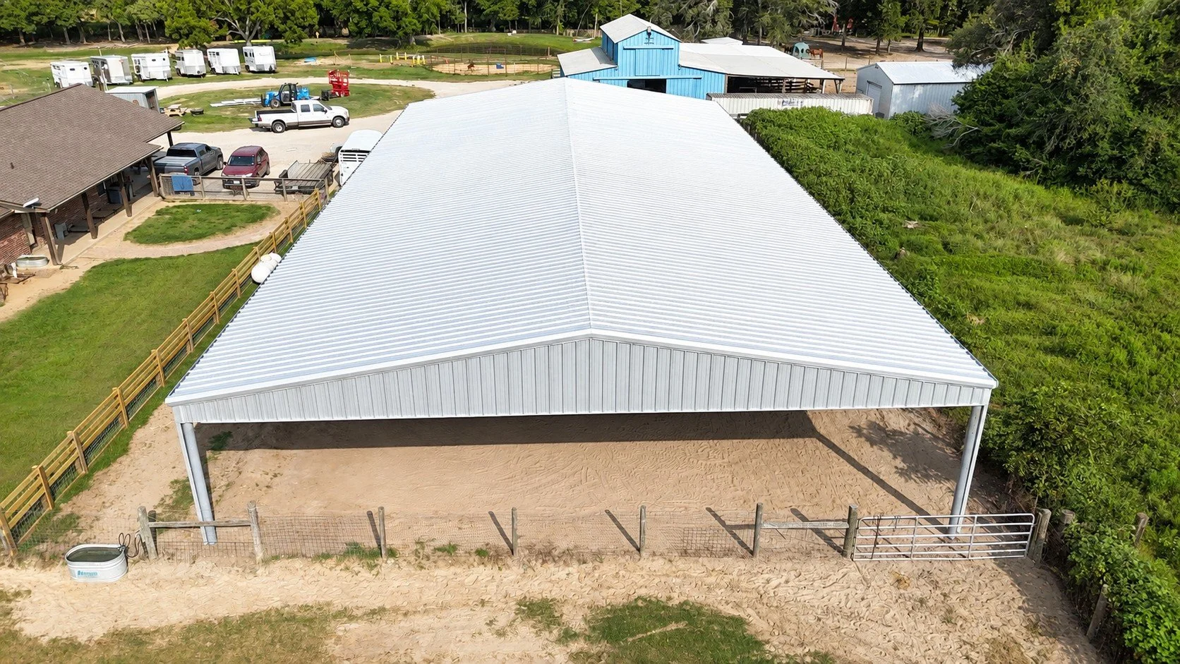 Custom 60x120 covered horse arena featuring steel construction, open sides, and a Galvalume roof by Wood's Construction.