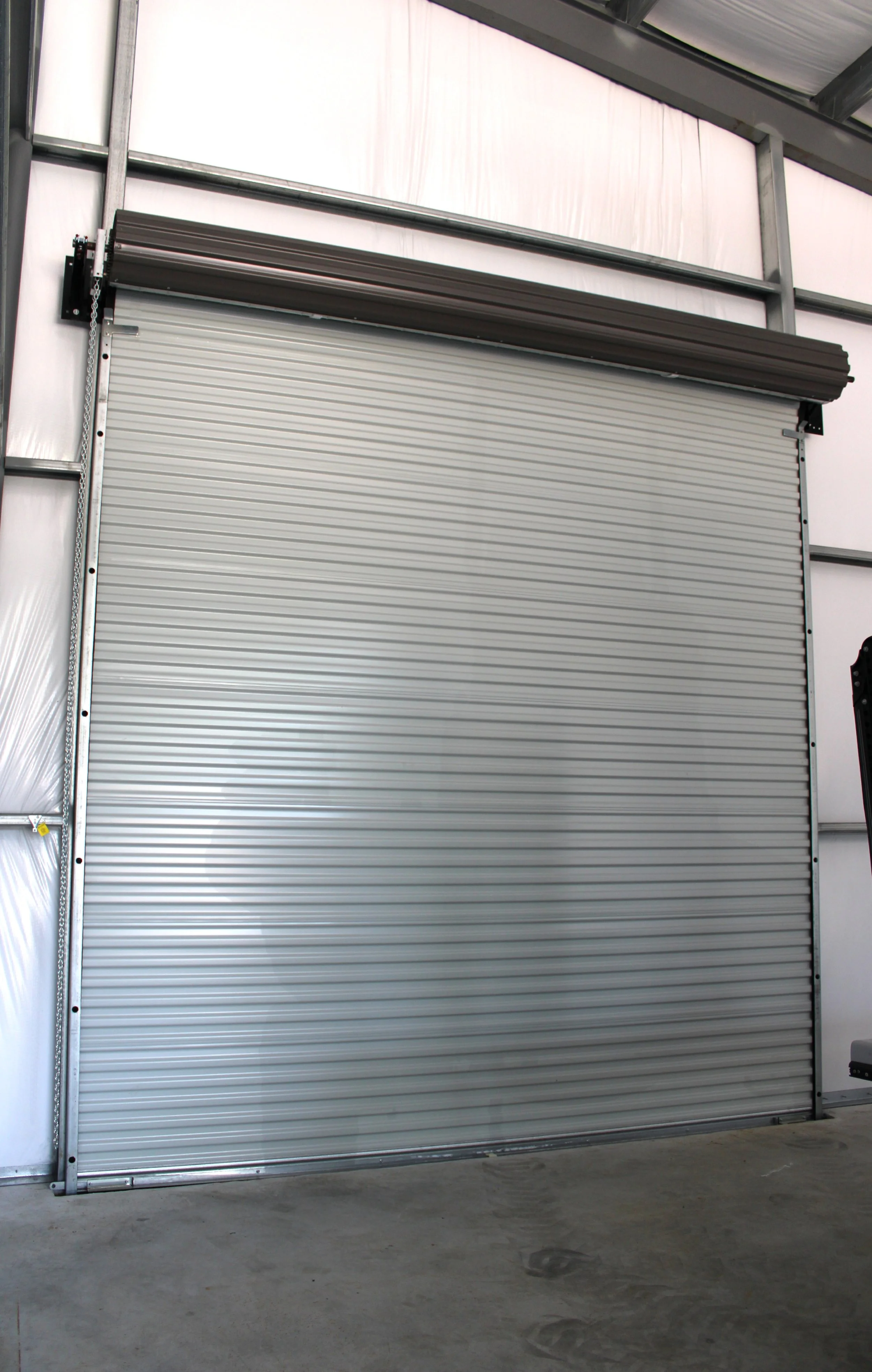 Interior 14x14 roll-up door inside custom boat storage metal building in Richmond TX with charcoal trim