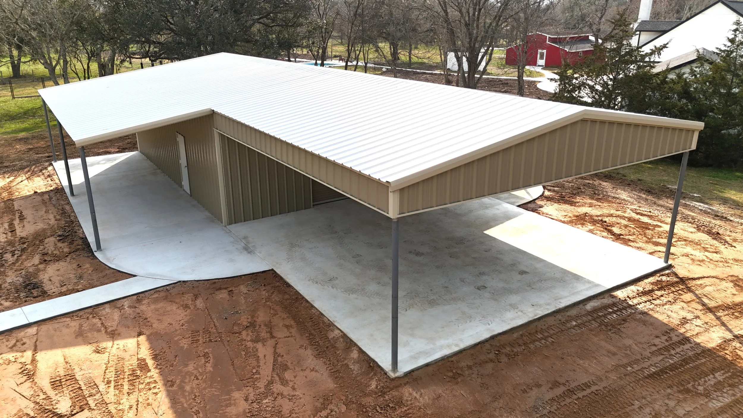 Concrete pathway connected to custom shop with dual lean-tos & large awning