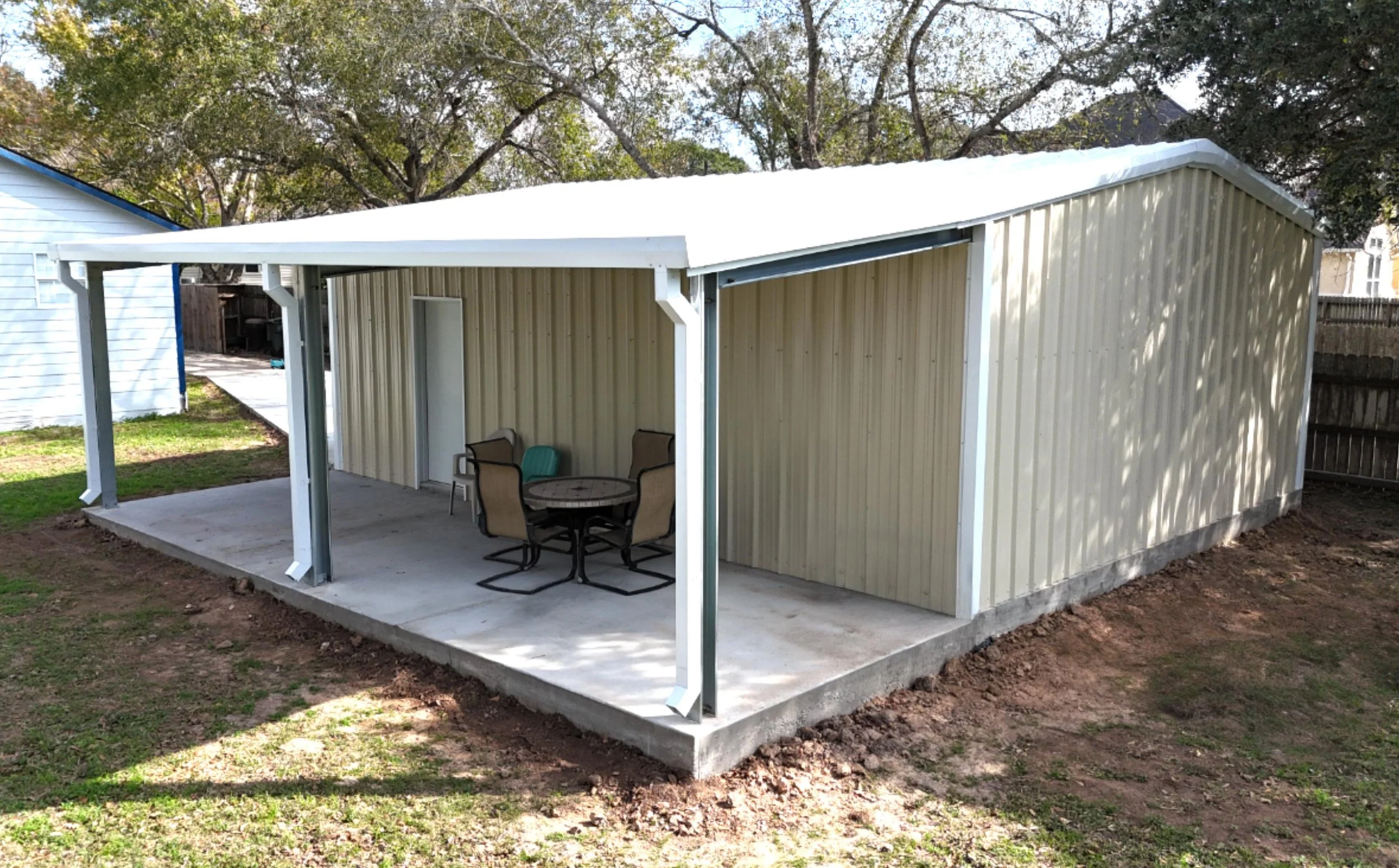 Wraparound covered porch providing shaded outdoor space integrated with the 20×25 custom metal shop and garage.