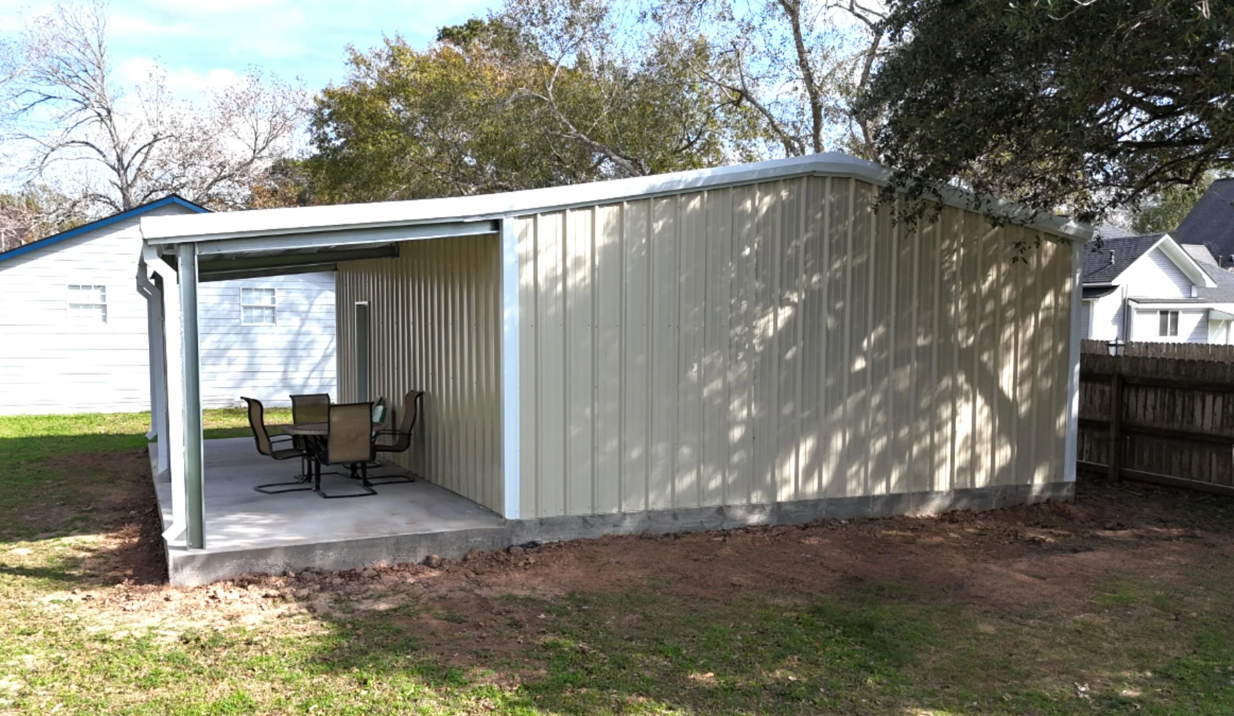 Covered porch extension providing shaded outdoor space alongside the 20×25 custom metal shop and garage.