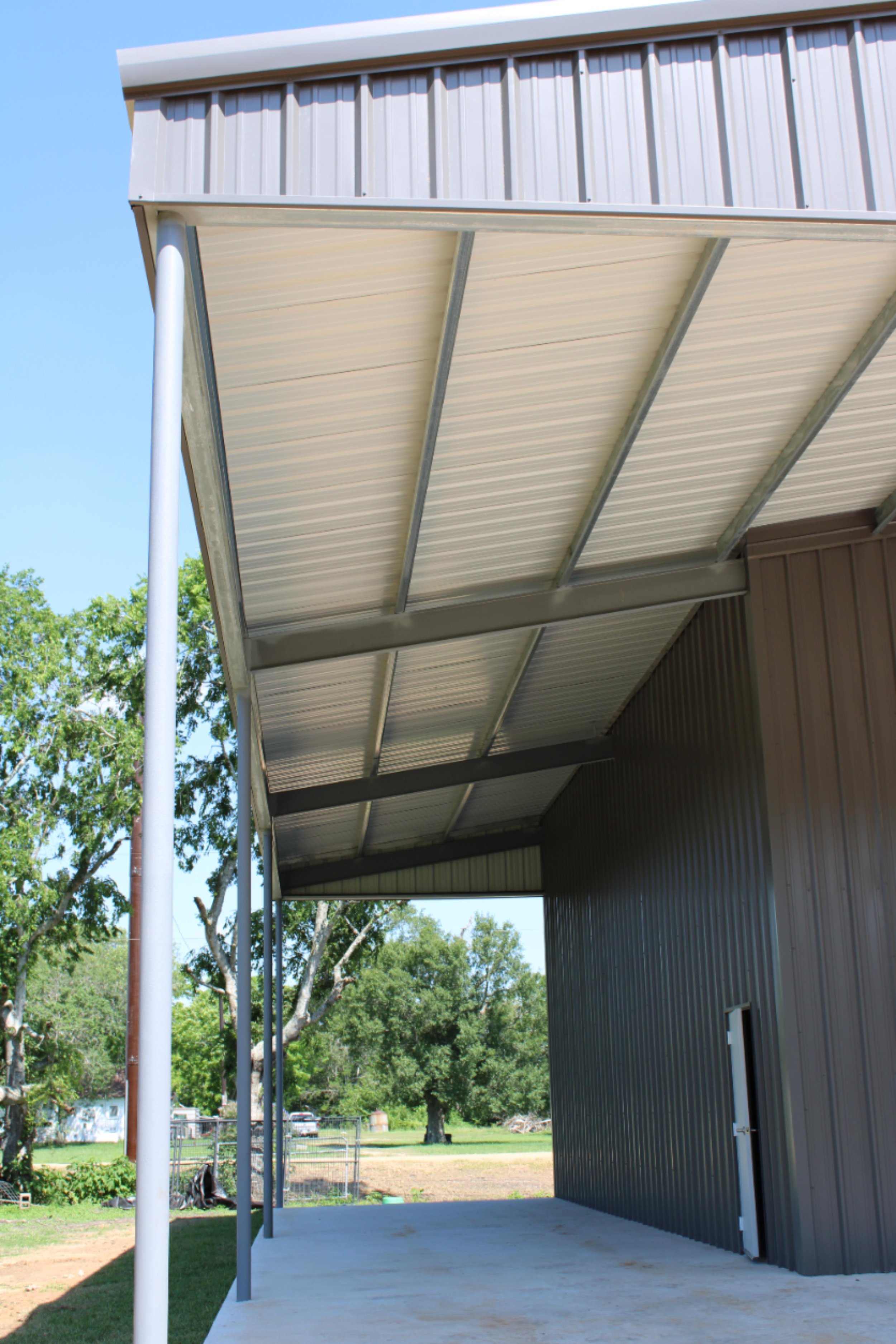 overed lean-to on custom metal building in Fort Bend County TX with galvanized framing and large concrete slab workspace