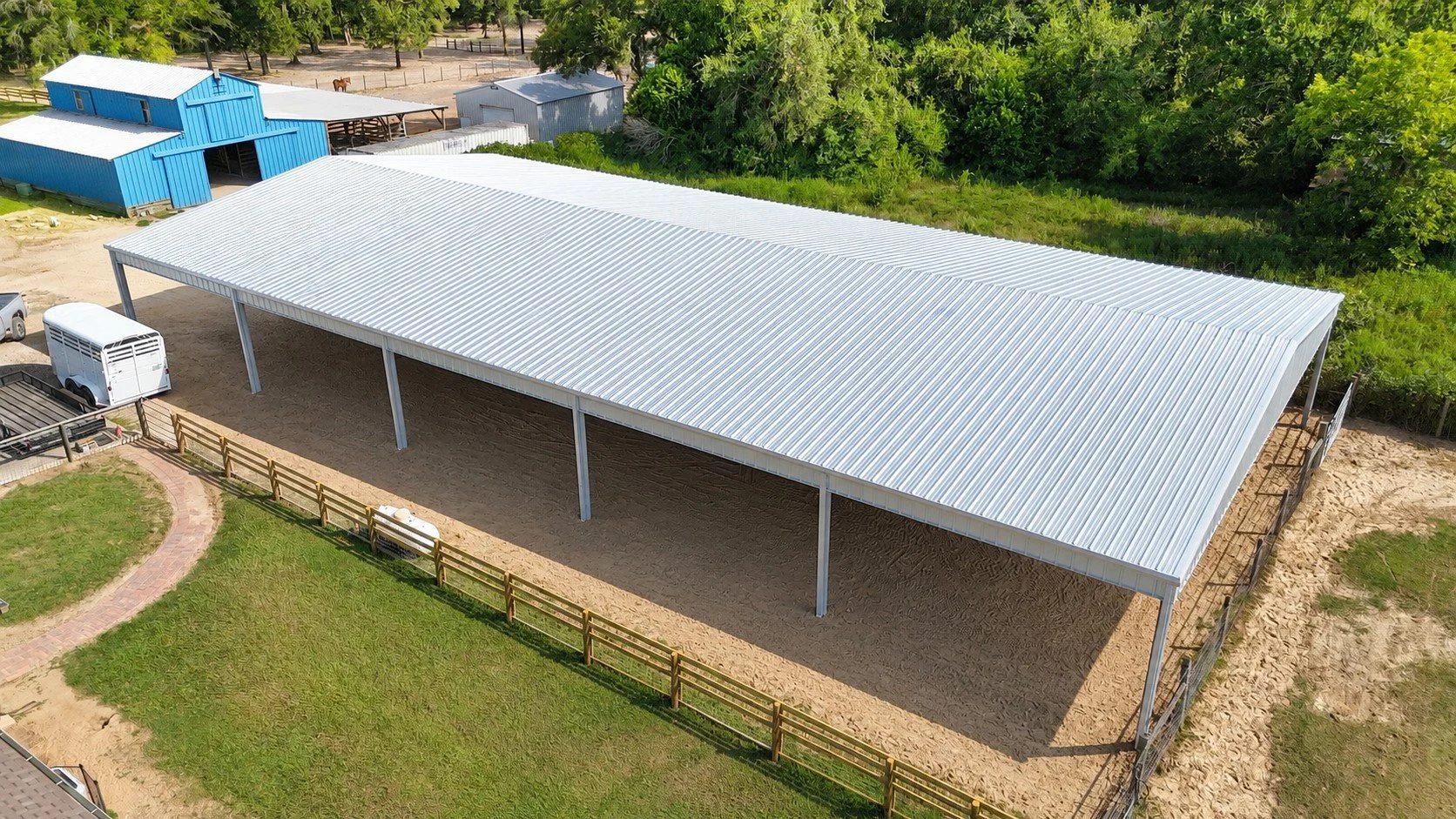 Front view of a custom covered horse arena designed for year-round riding and horse training in Texas.
