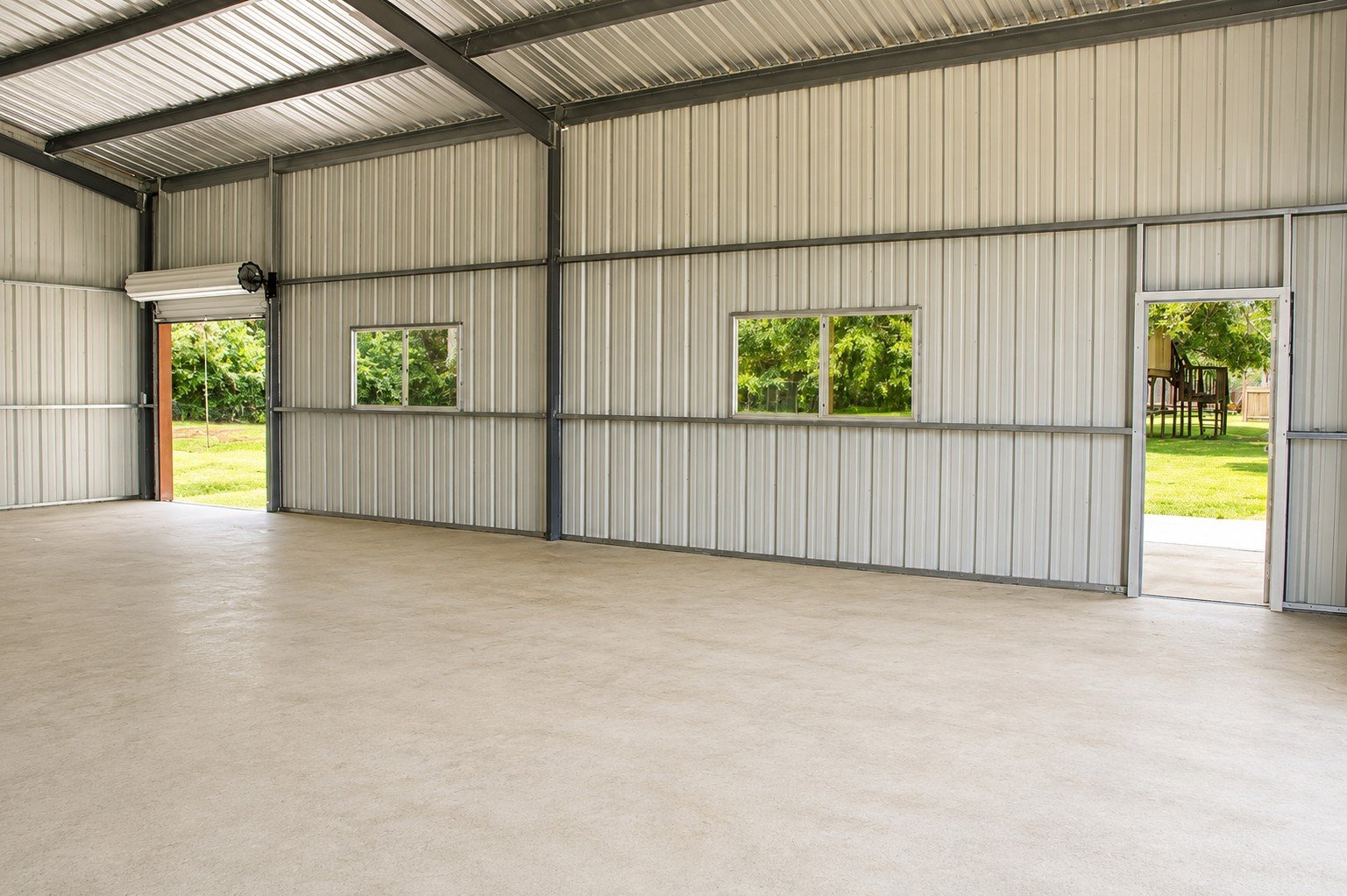 Natural light fills the shop through strategically placed windows and large roll-up doors, creating a bright and functional workspace.