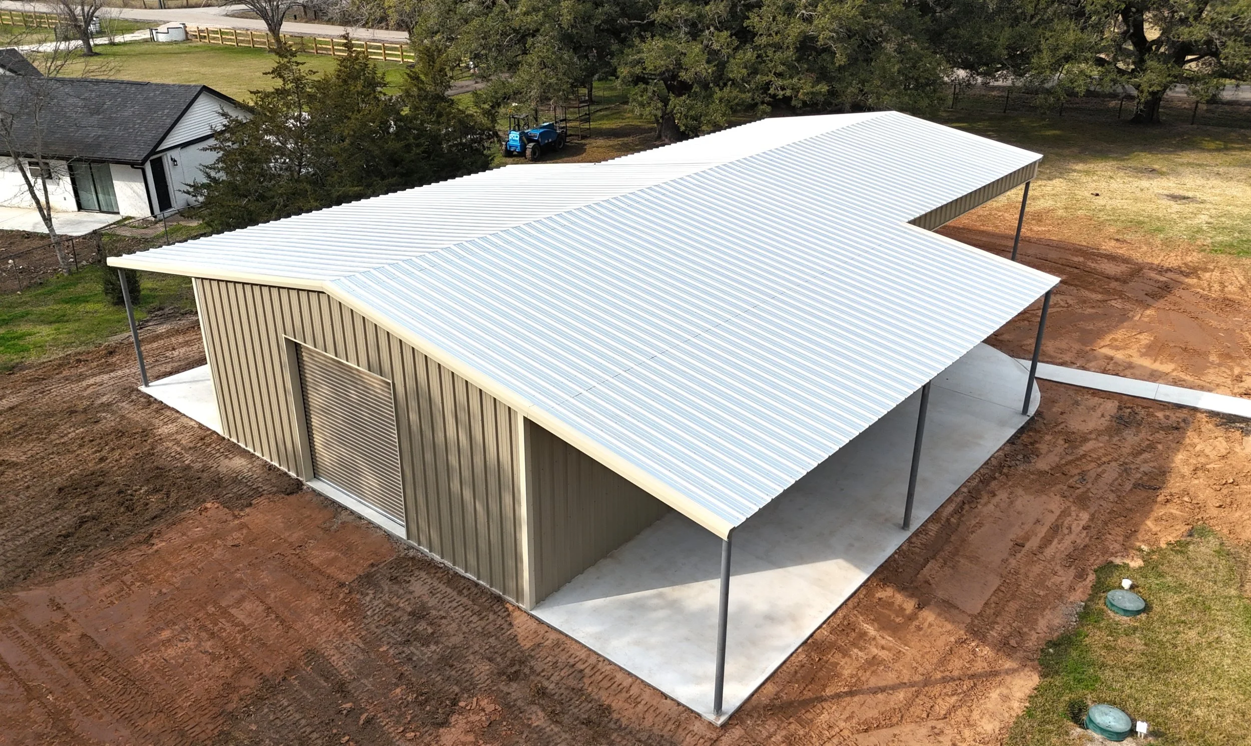 Rear angle of galvanized steel shop with extended concrete pad and steel framing in Brazoria County, TX