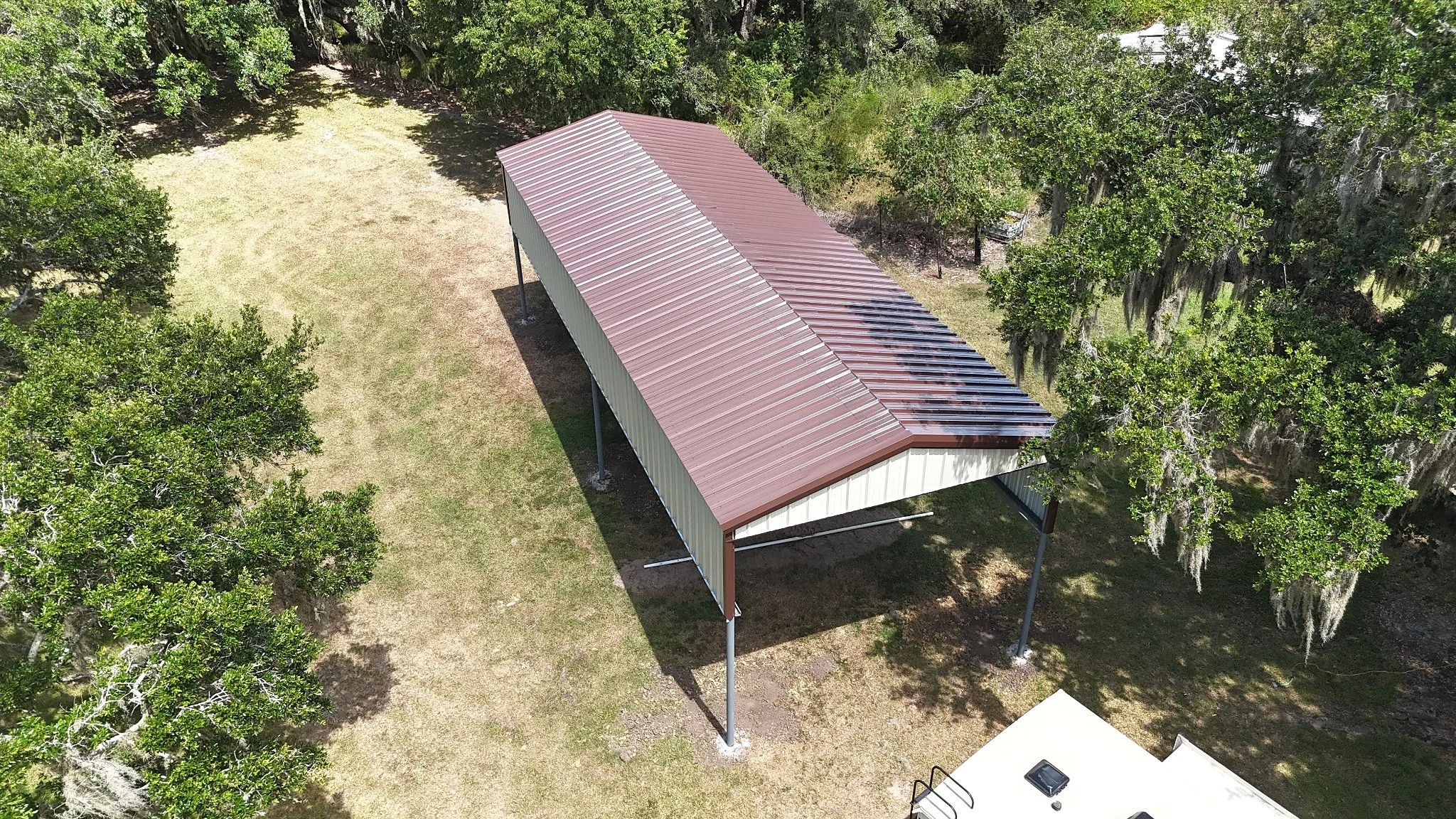 Aerial view highlighting the full 50-foot length of the custom steel RV cover and its pitched metal roof.