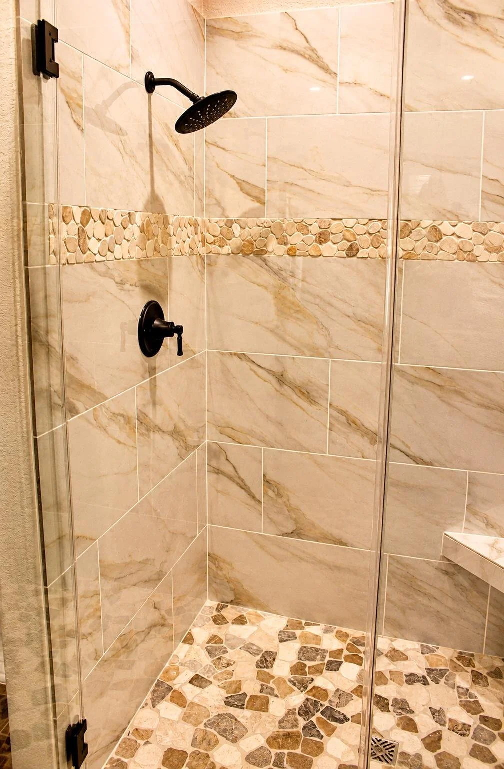 Custom tile walk in shower with glass door with matte black fixtures in barndominium built in Wharton County, TX