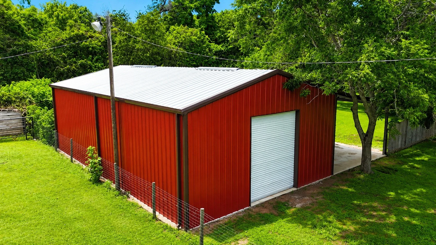 Angled view highlighting the shop's custom color combination, covered outdoor space, and durable weld-up steel construction.