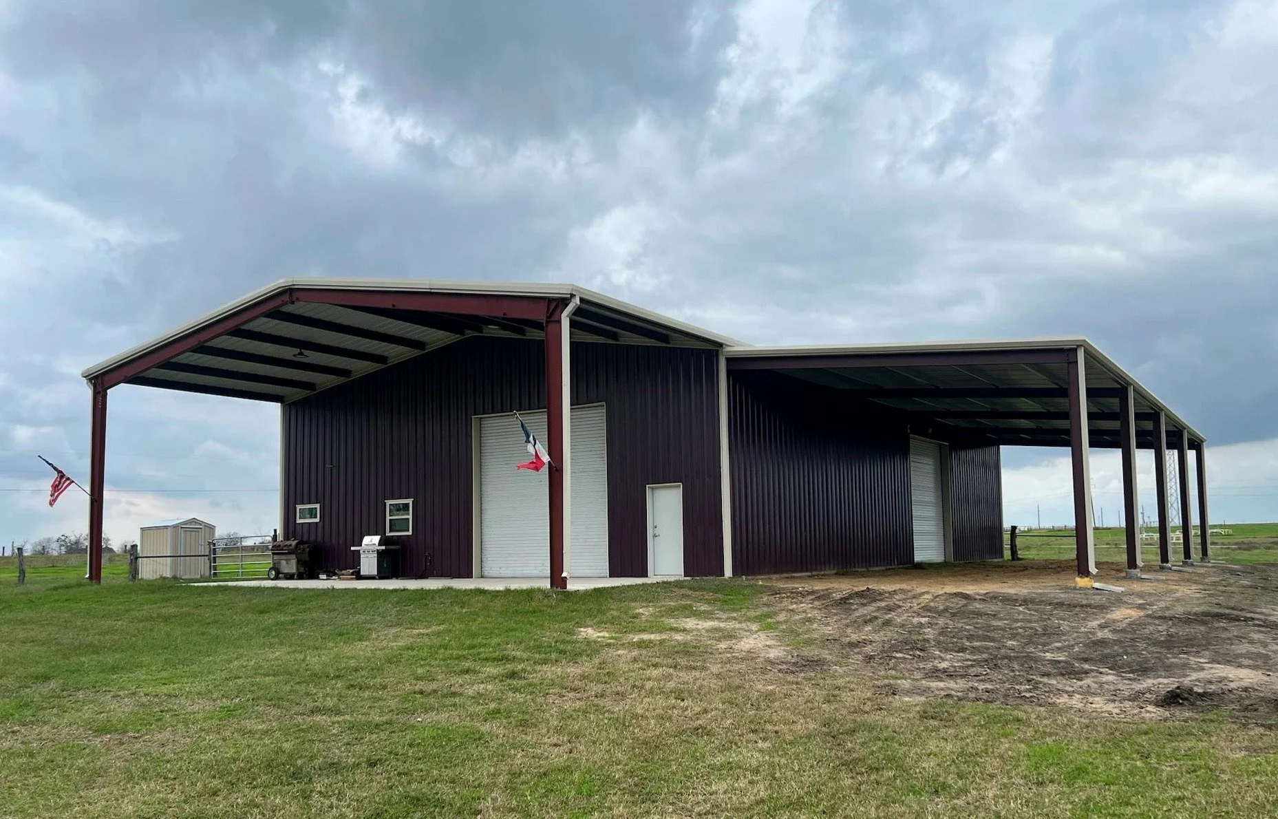 Burgendy Metal garage with front awning and side lean-to in South Texas