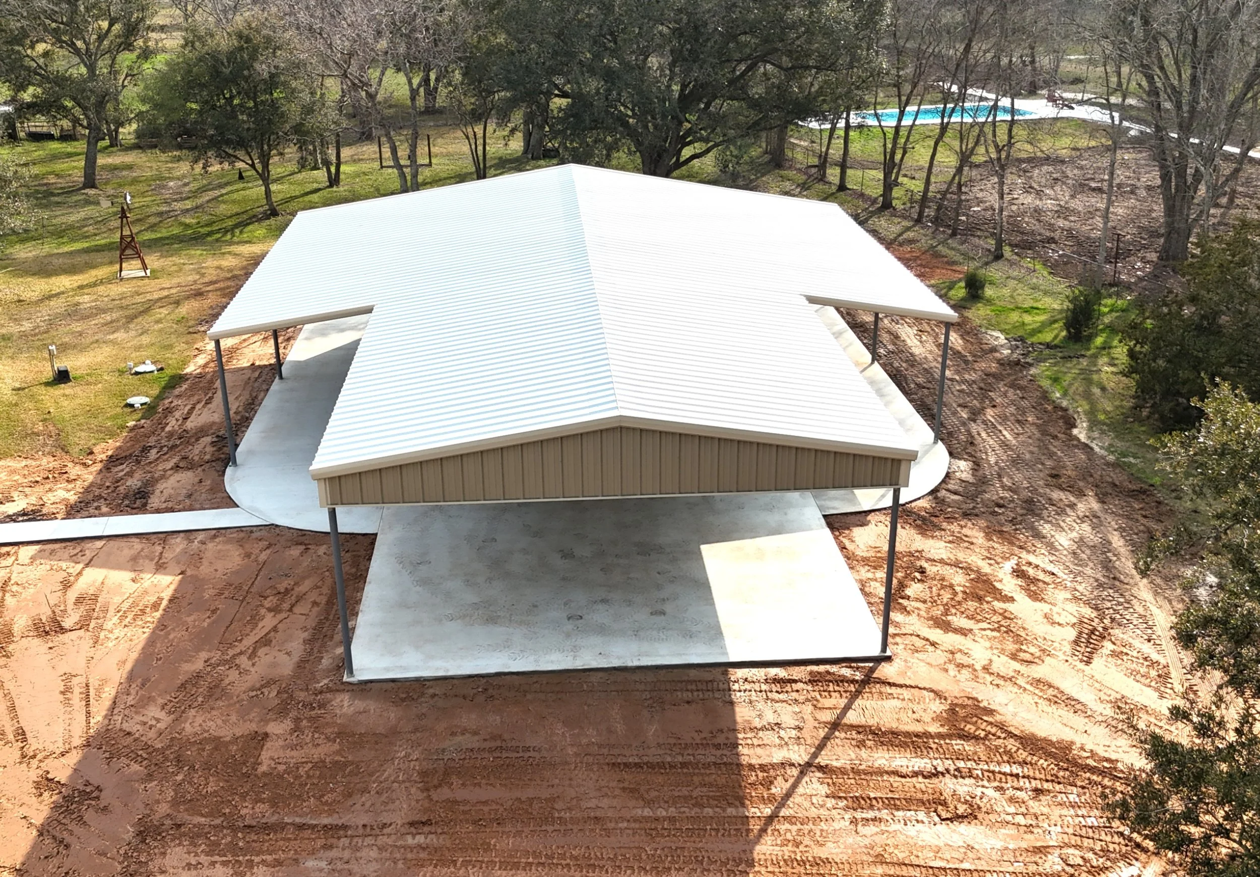 Aerial view of custom 30x40 galvanized steel metal shop with dual lean-to’s and full-length awning in Damon, Texas