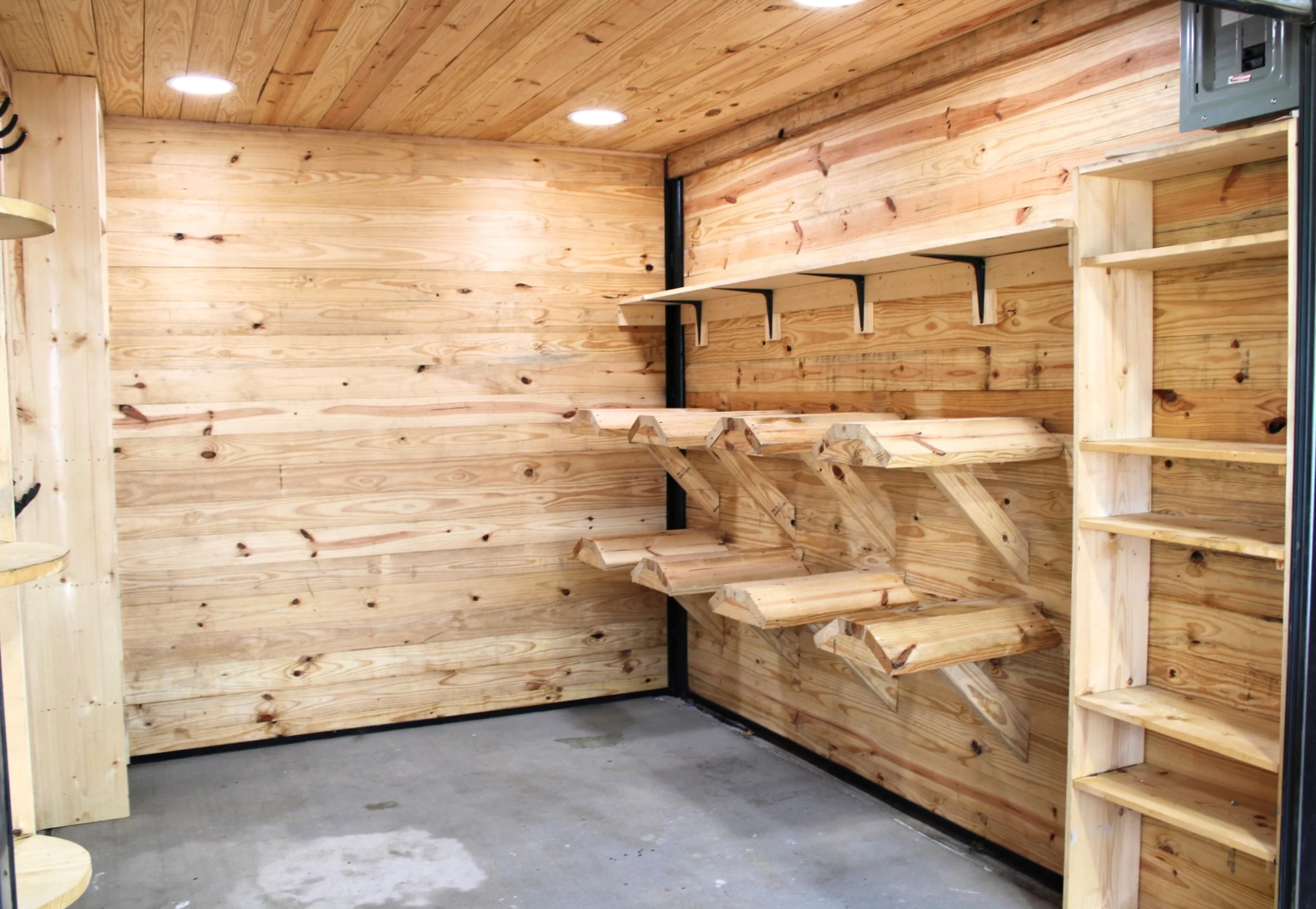 Custom pine board tack room with saddle racks, shelving, bridle hooks, roll up door in Bellville, TX