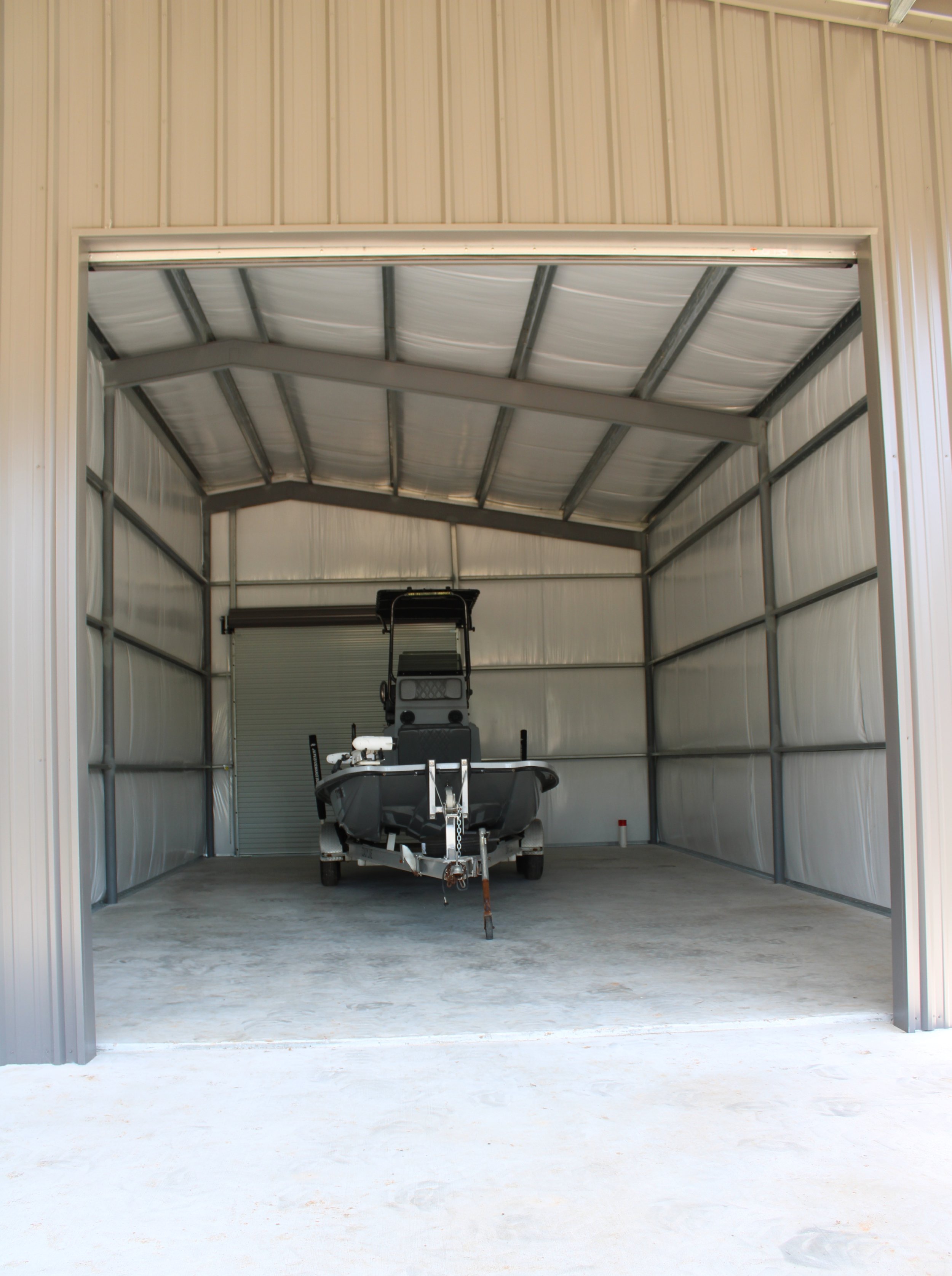 Insulated enclosed metal shop in Richmond TX with boat storage, full concrete slab, and 14x14 roll-up door