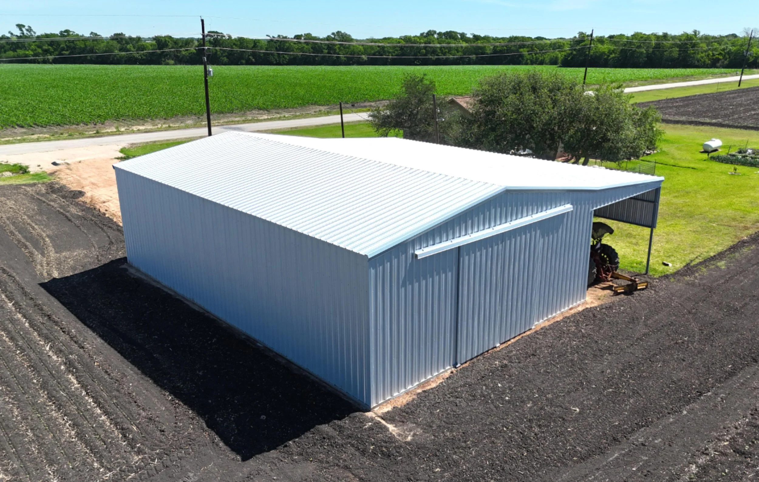 Custom agricultural shop with full lean-to overhang, galvalume steel construction, East Bernard TX