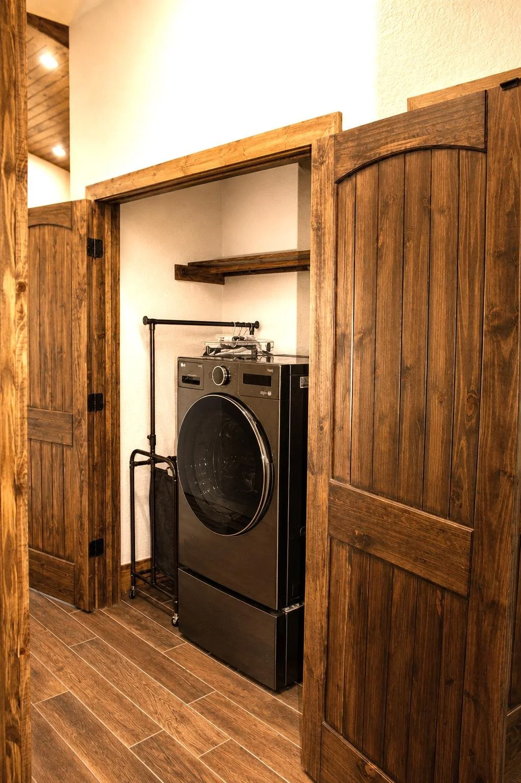 Interior detail of custom rustic doors for laundry nook and warm farmhouse finishes inside Texas barndominium