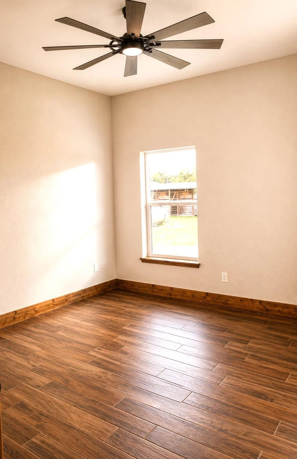 Spacious master bedroom with wood tile flooring and ample light.