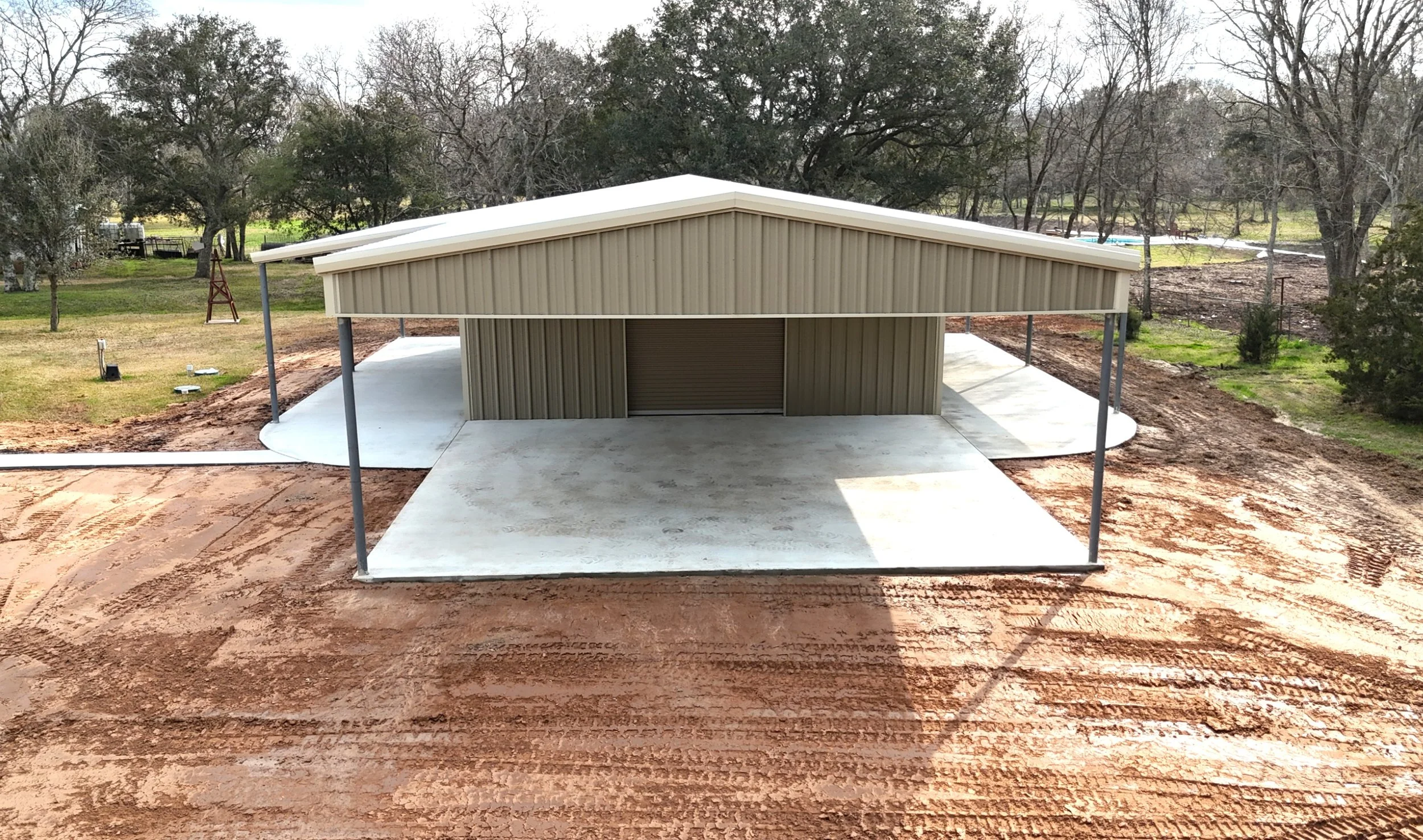 Aerial view of custom 30x40 galvanized steel metal shop with dual lean-to’s and full-length awning in Damon, Texas