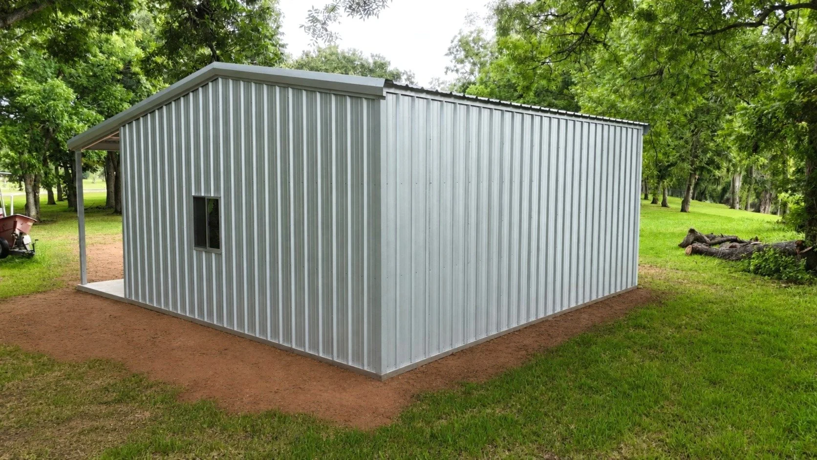 Rear corner view showing the clean R-panel siding, window, galvanized trim, and compact design of this custom steel building.