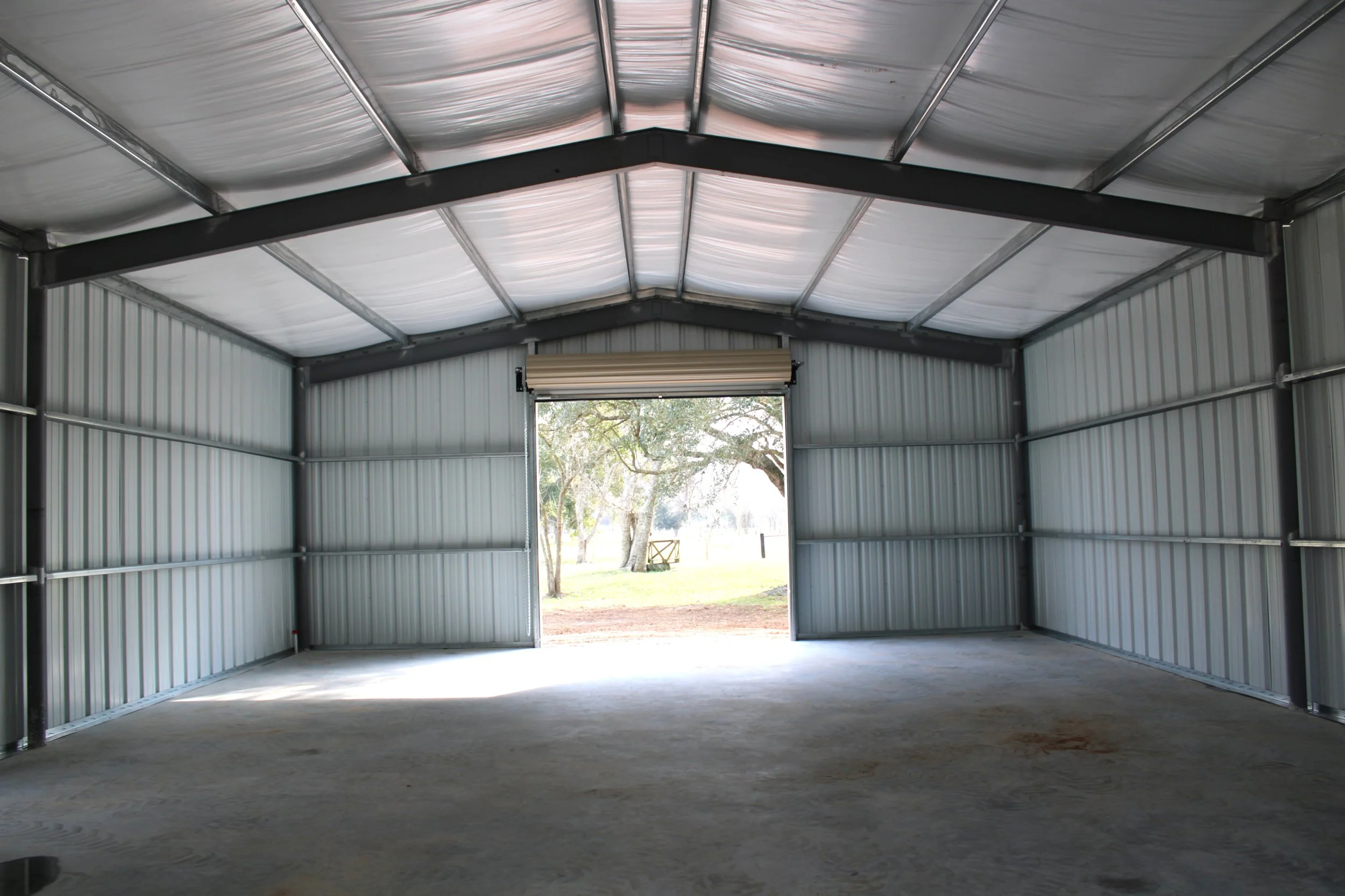 Interior view of open metal shop with galvanized steel framing and insulated roof in Brazoria County, Texas.