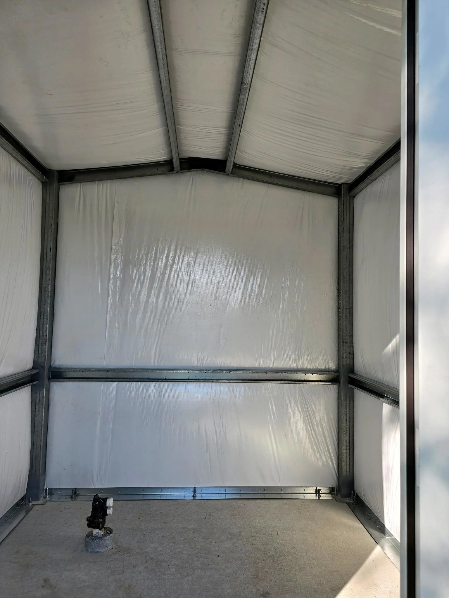 Interior view of custom metal shop showing insulated walls, steel framing, and concrete slab floor in Fort Bend County, Texas.