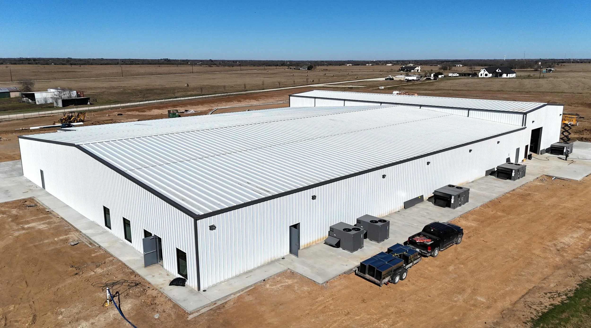 Commercial metal building in Bryan, TX showing completed steel structure with exterior wall panels, roof system, and concrete perimeter designed for commercial use.