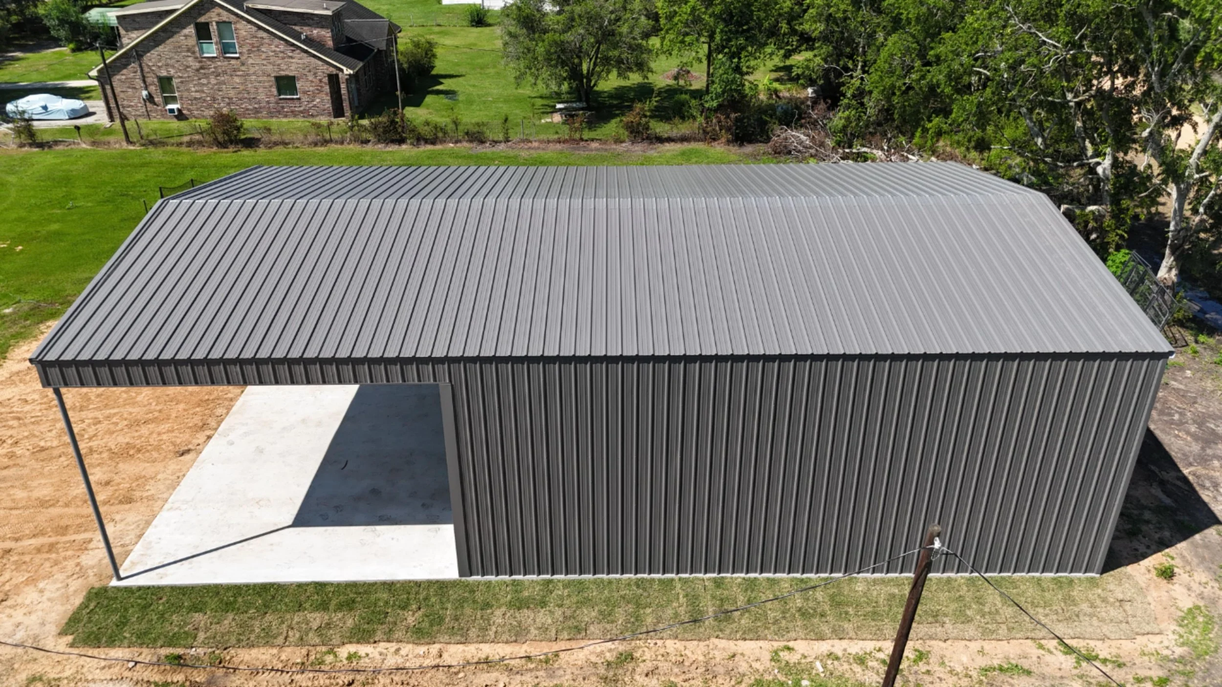 Overhead view of 70x40 custom boat storage metal building in Richmond TX with enclosed shop and extended front covered slab