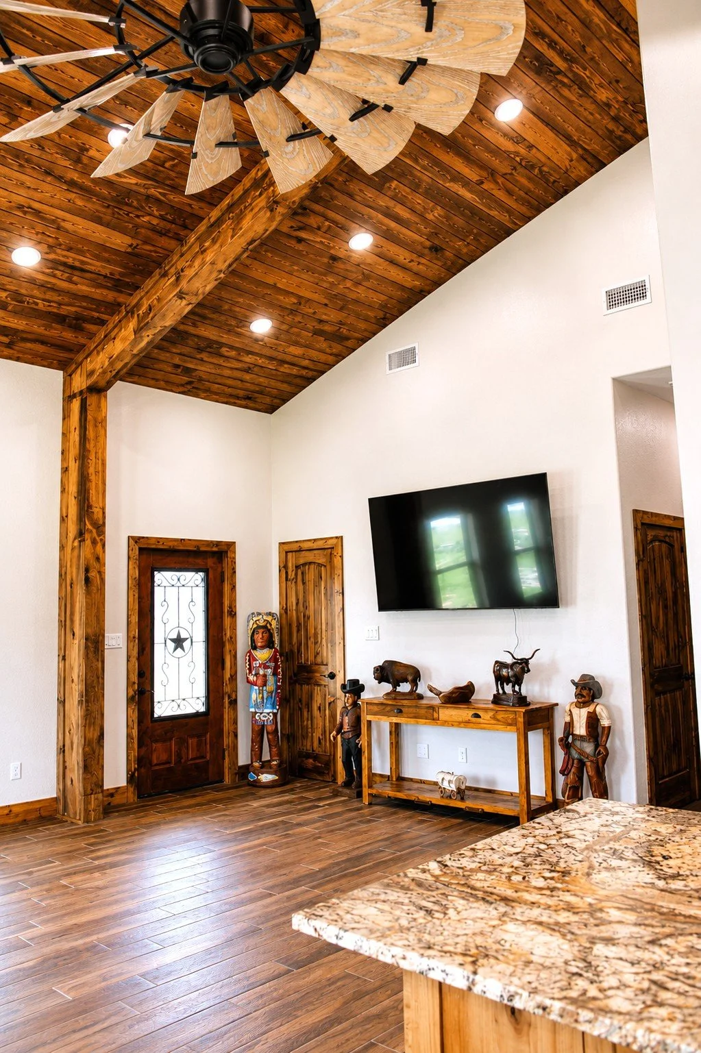 Modern rustic living space with vaulted ceilings, exposed beams, and open floor plan