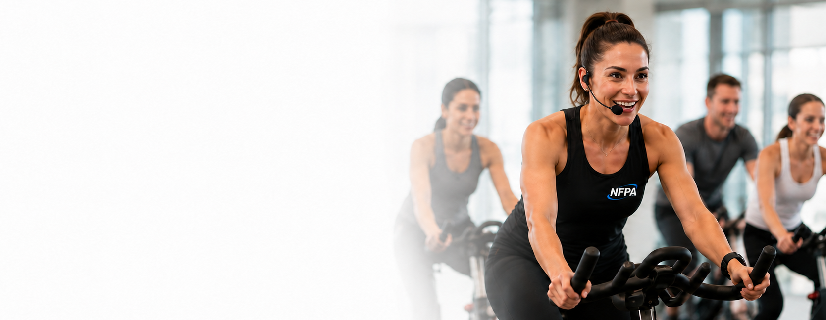 NFPA indoor cycling instructor leading a motivating indoor cycling class
