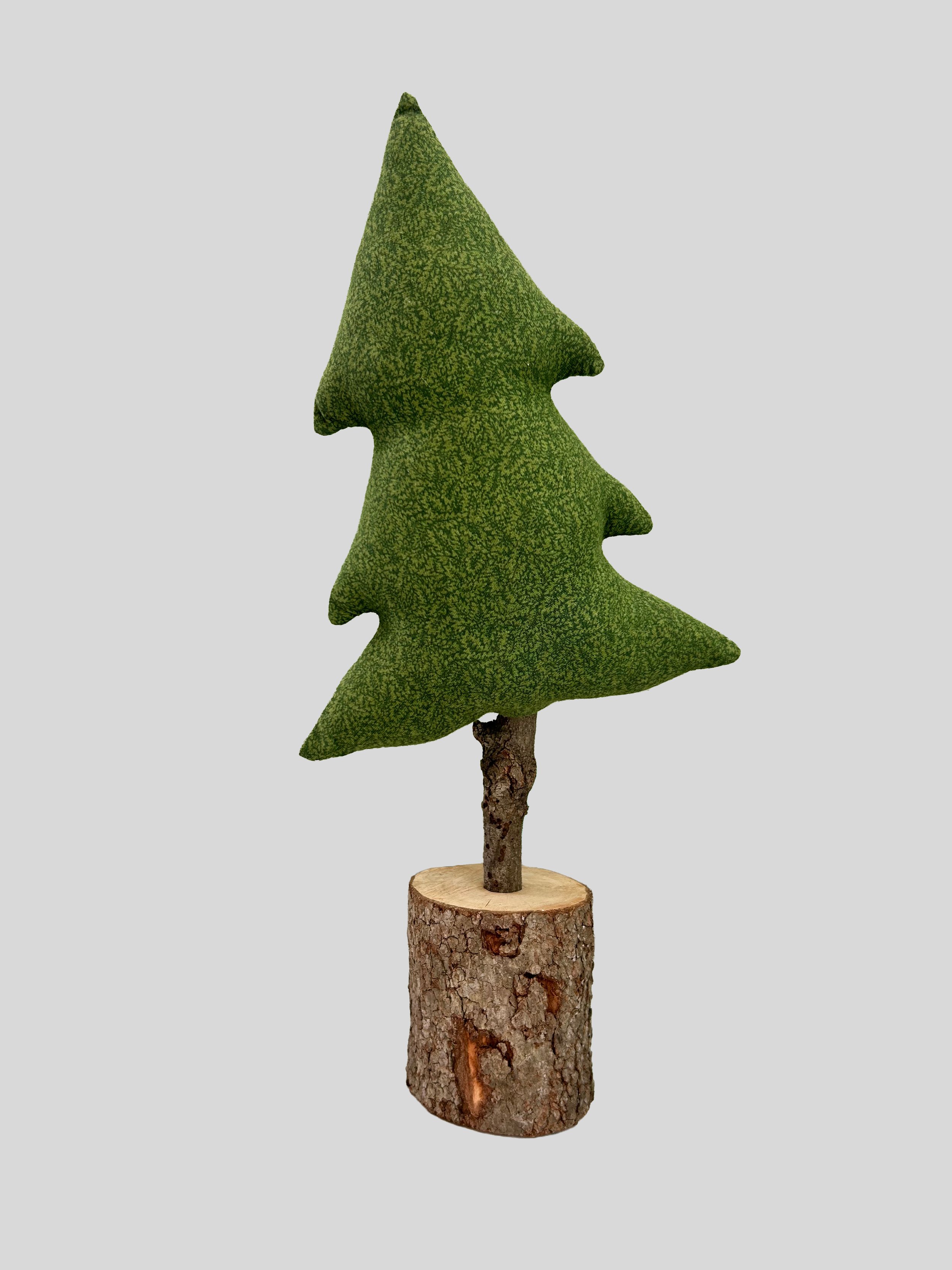 A Christmas Tree holiday craft made of green fabric and wood, mounted on a tree trunk base.