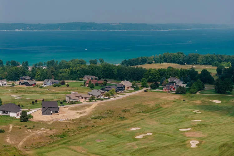 Aerial of homes and golf course with the bay beyond