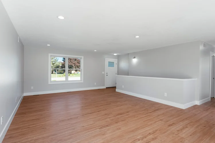 Living room with front door and plank flooring