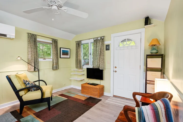 Living room with ceiling fan and front door